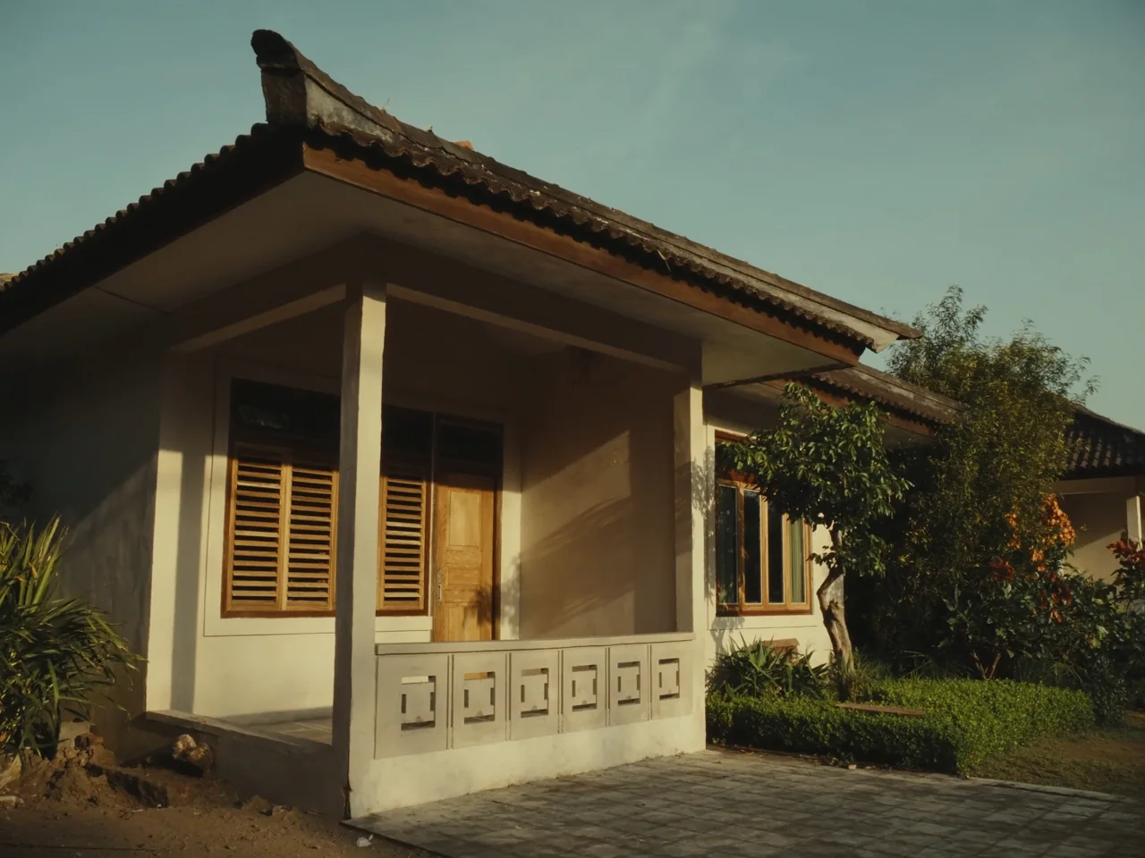 Rumah tropis yang terawat dengan taman hijau — ilustrasi AI